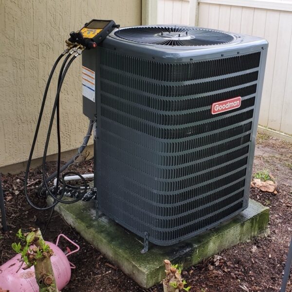 Technician servicing residential air conditioner