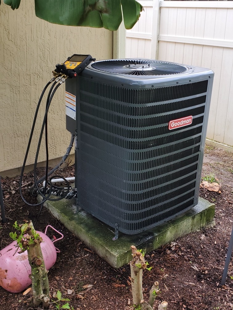 Technician servicing residential air conditioner